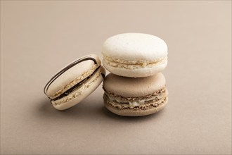 Brown and white macaroons on beige pastel background. side view, close up, still life. Breakfast,