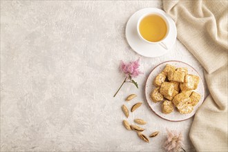 Traditional turkish delight (rahat lokum) with cup of green tea on a gray concrete background and