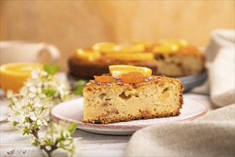 Orange cake and a cup of coffee on a white wooden background and linen textile. Side view, close