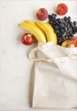 Fruits in reusable cotton textile white bag. Zero waste shopping, storage and recycling concept,