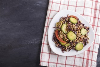 Vegetarian salad of purple cabbage, germinated wheat, tomatoes and avocado on linen tablecloth,