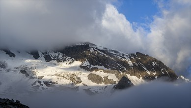 Cloudy mountain landscape in dramatic morning light, Griesferner summit with glacier, Berliner