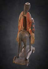 Back view of the Palmesel, wooden figure from around 1380, painted on a dark background,