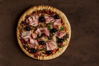 Pizza with prosciutto and mushrooms, bacon, olives, homemade, top view, no people