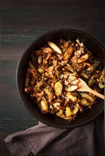 Fried chanterelles with mushrooms, in a clay pan, close-up, top view, selective focus