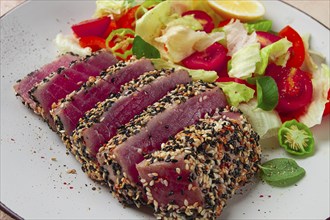 Fillet of red tuna meat, fried in sesame seeds, homemade, close-up, no people, on a wooden