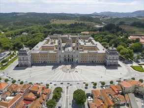 Aerial view of a historic palace in baroque style, surrounded by green vegetation and old building