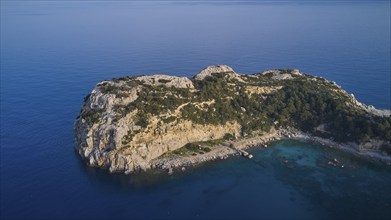 Drone shot, Steep rocky island with dense vegetation surrounded by clear blue sea, Anthony Quinn