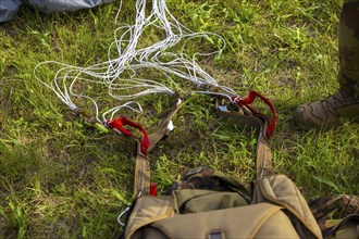 Military Parachuter Standing on the Grass with His Parachute in Switzerland