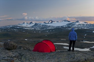 Hiker looks out from his tent towards the Sulitelma massif with the Sulitelma glacier, Laponia