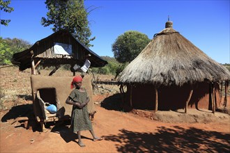 South Ethiopia, Benna people, house, hut, woman in front of her round hut in a Benna village,