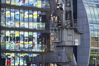 Old crane in front of the glass façade of an office building, reflecting the Colorium high-rise,