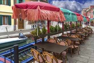 Colourful parasols in a restaurant on the canal, Burano, Venice, Veneto, Italy, Europe