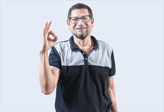 Smiling elderly man gesturing OK isolated. Cheerful old man gesturing approved on white backgroud