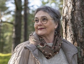 Portrait of elderly woman, 65 years old, enjoying nature in the forest in Ystad, Skåne, Sweden,