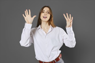 Inspired young woman shows nine fingers. Counting with fingers concept