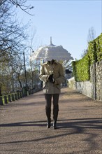 Woman Walking with Her Elegant Umbrella on Walkway in a Sunny Day in Locarno, Ticino, Switzerland,