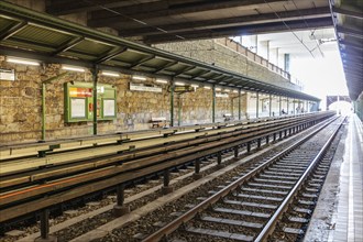 Underground station with empty tracks and covered platforms, light and shadow, Vienna