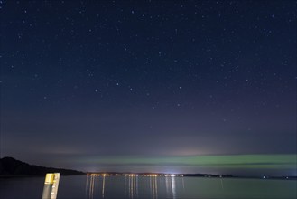 Northern lights (aurora borealis) shine on a starry night over Lake Plau, Ganzlin,