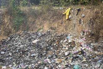 Coking rubbish dump, rubbish pit with waste and plastic rubbish, karst landscape near Vang Vieng,