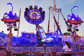 People on the illuminated carousel Mr Gravity in the evening, Cranger Kirmes, Herne, Ruhr area,