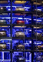 An illuminated car tower with new cars for delivery in the evening, detail, Autostadt, Volkswagen