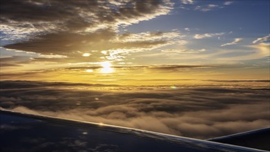 Flight over a sea of clouds at sunrise, brilliant light and clear view, flight, aerial photography