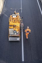 Marking work after the application of new whisper asphalt surface for the A40 motorway, in the