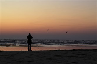 Sunrise on the Baltic Sea beach near Karlshagen, man with camera, September, Usedom,