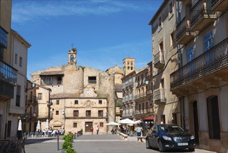 Lively square with buildings, a bell tower and street cafés in sunny weather, Castillo, old castle