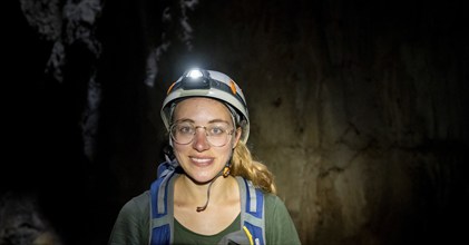 Tourist in a cave with helmet and headlamp, Barra Honda National Park, Costa Rica, Central America