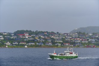 A fishing trawler at sea, in the background Alesund, Fylke, Norway, Europe