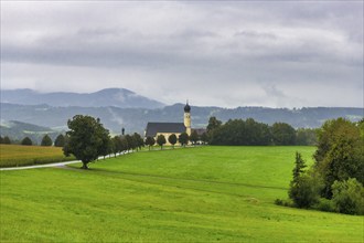 Pilgrimage church of St Marinus in Wilparting surrounded by wide green meadows and trees, under a