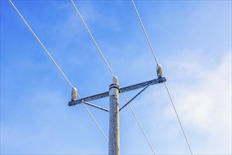 Frosty power line pole against a blue sky in the winter, Sweden, Europe