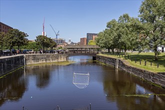 Cityscape with bridge and trees by a river in summer, Liverpool