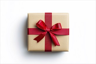 Top view of Christmas gift box wrapped in brown craft paper and red ribbon on white background.