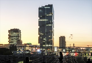 Sunset at the Modersohn Bridge, view of railway tracks, trains and the 140 metre high Amazon office