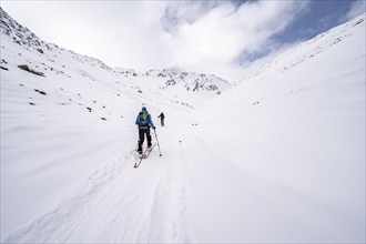 Two ski tourers climbing up to the Madritschspitze, snow-covered mountain landscape, Madritsch