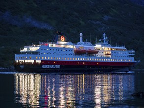 Hurtigruten cruise ship passes the Raftsund at night, the strait between islands Hinnøya and