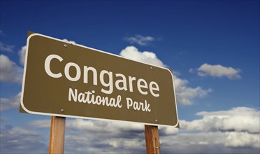 Congaree national park (south carolina) road sign against blue sky and clouds