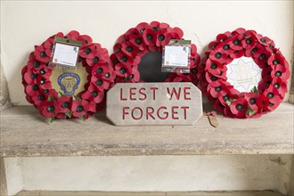 Lest We Forget remembrance poppy wreaths, Orford church, Suffolk, England, UK