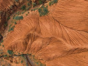 Eroded mountain landscape, top-down, canyon with red and orange rock formations, aerial view,