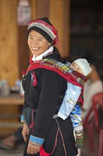 Vietnamese woman, 43 years old, in traditional traditional costume of the Dao minority, carrying