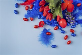 Cheerful Easter decoration with a red egg surrounded by tulips and feathers