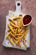 Fried French fries, in a paper bag, on an abstract background, no people, rustic