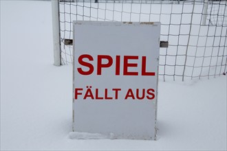 Symbolic image of a football match cancelled due to snow. Sign on a sports field with the