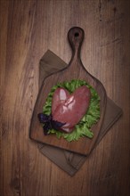 Raw pork kidneys, on a chopping board, close-up, top view, no people