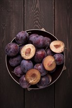 Blue plum, on a wooden table, top view, close-up, no people