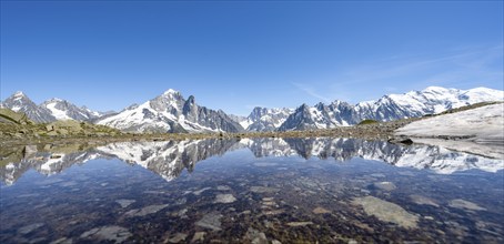 Mountain landscape, reflection in a small mountain lake, mountain peaks Aiguille Verte, Grandes