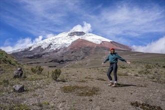 Women poses in front of the Cotopaxi volcano, Cotopaxi, Cotopaxi National Park, Latacunga, Ecuador,